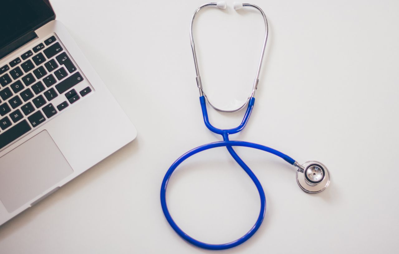 services-04 Medical stethoscope and laptop on a white desk, symbolizing digital health solutions.